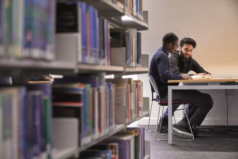 Students sitting at a table in a library